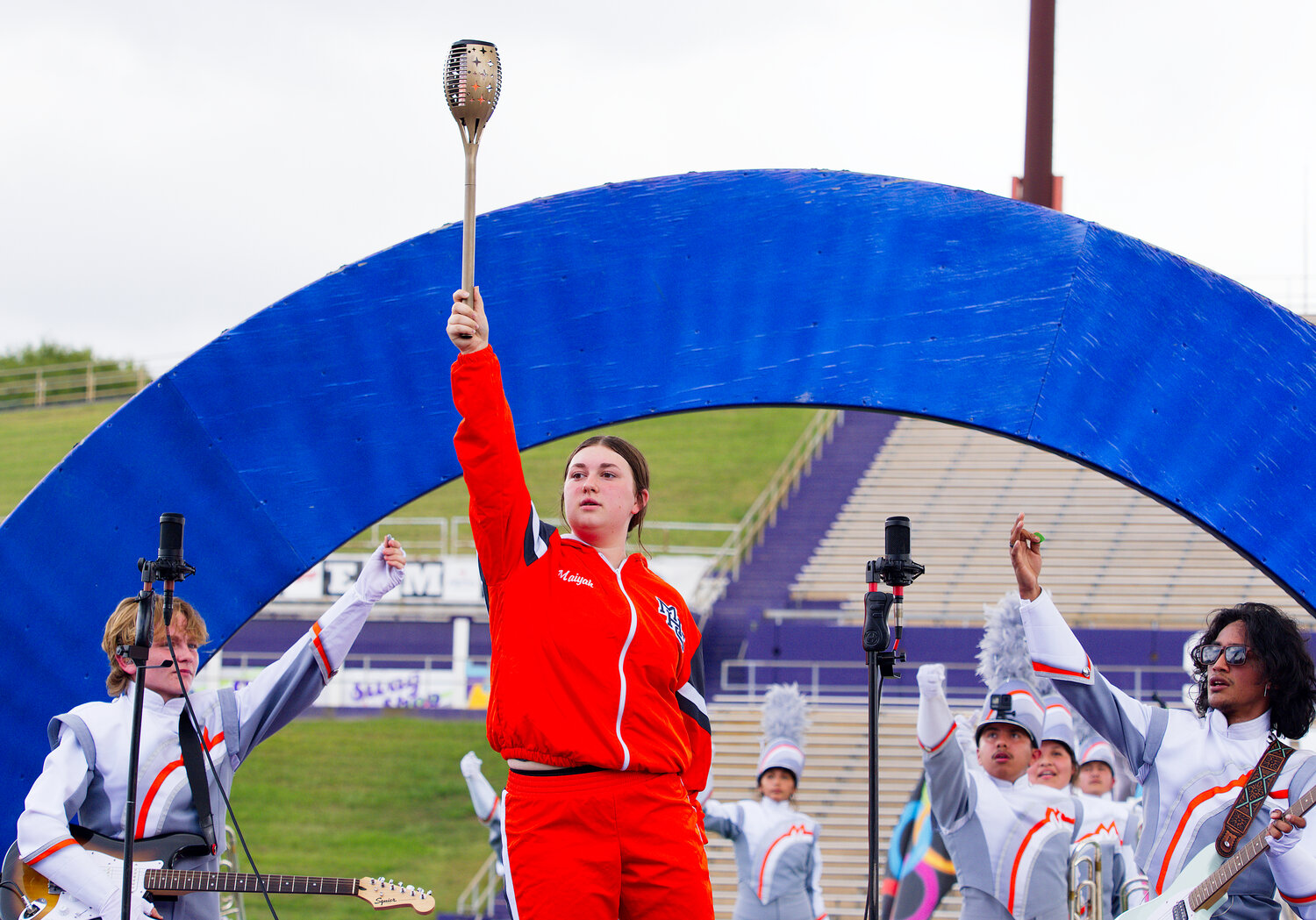 The Olympic torch is raised to conclude Mineola’s performance at the area marching contest. [see additional area shots]
